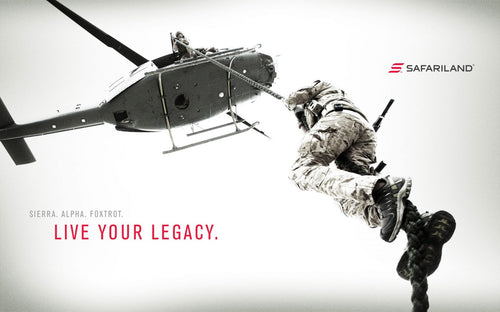 Person in military gear being rescued by a helicopter with 'Safariland' branding.