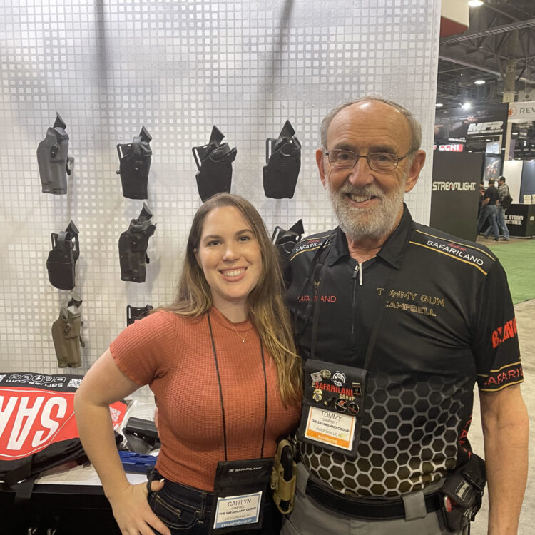 Tommy Campbell and his wife standing in front of a display with Safariland products.