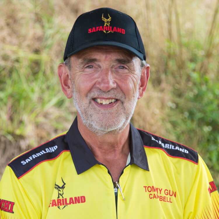 Tommy Campbell wearing a yellow Safariland shirt and black cap with a logo in a natural setting