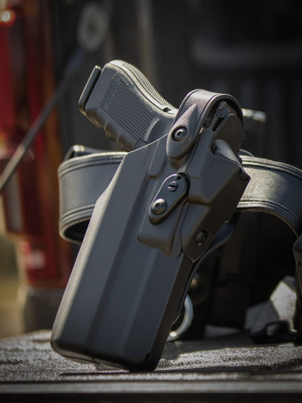 Black gun holster with a gun on a textured surface
